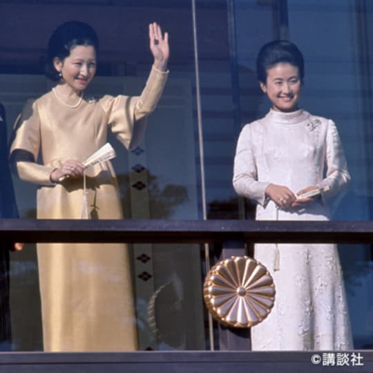 昭和46年1月2日、皇居で行われた新年の一般参賀で手を振られる美智子さま。華やかな色のドレスを主役に、控えめなパールのネックレスを合わせています。