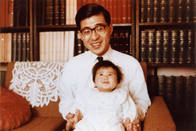 父の恆さんが生後3ヶ月の雅子さまを抱えて椅子に座っている写真