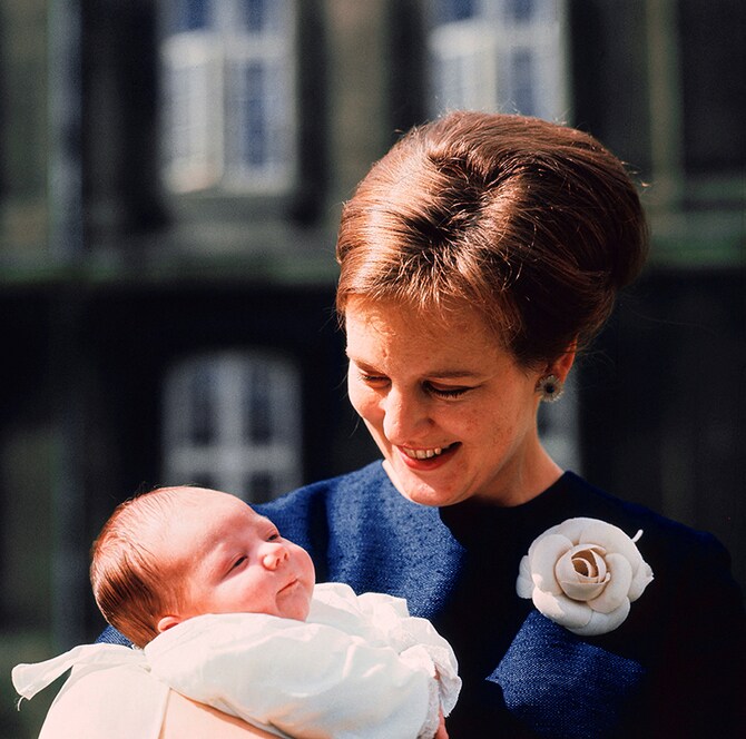 つい先日、退位を表明されたデンマークのマルグレーテ王女。当時誕生されたばかりの長男、フレデリック皇太子（まもなく国王フレデリック10世に）を抱っこされるご様子。1968年6月に撮影。写真：ロイター/アフロ